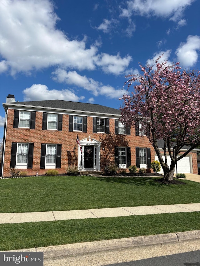 12527 Misty Water Dr, Herndon, VA 20170 - colonial inspired home with a chimney, a front yard, and brick siding