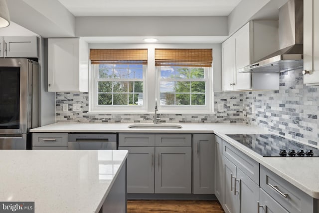 12527 Misty Water Dr, Herndon, VA 20170 - kitchen with wall chimney range hood, a sink, light stone counters, and stainless steel appliances
