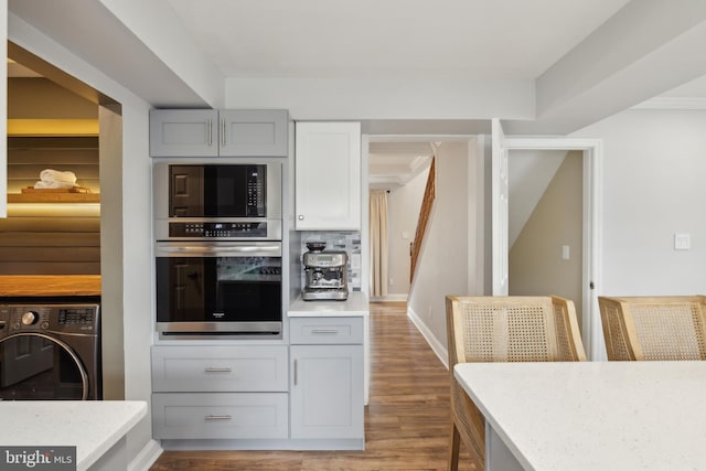 12527 Misty Water Dr, Herndon, VA 20170 - kitchen with gray cabinetry, black microwave, stainless steel oven, and wood finished floors