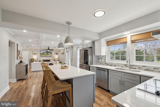 12527 Misty Water Dr, Herndon, VA 20170 - kitchen with a sink, stainless steel appliances, decorative backsplash, a kitchen island, and gray cabinetry
