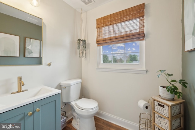12527 Misty Water Dr, Herndon, VA 20170 - half bathroom with wood finished floors, toilet, vanity, baseboards, and visible vents