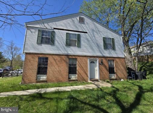 view of front of house featuring brick siding and a front lawn