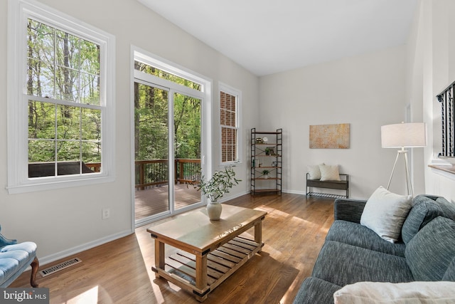 living room with visible vents, wood finished floors, and a wealth of natural light