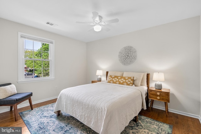 bedroom featuring baseboards, visible vents, wood finished floors, and ceiling fan