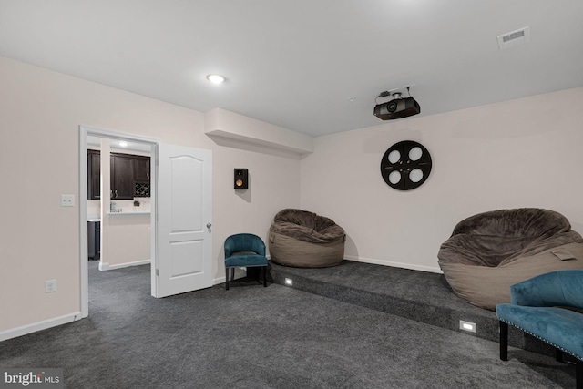 sitting room with baseboards, dark carpet, and visible vents