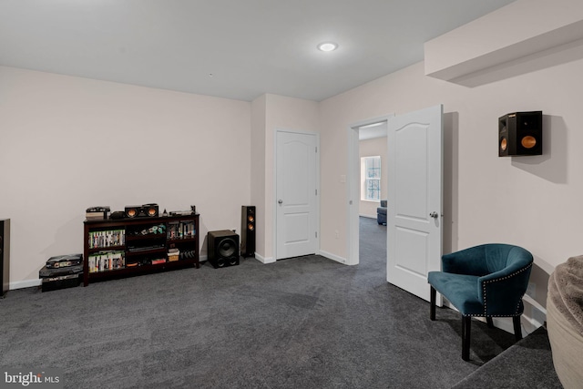 sitting room with baseboards and dark carpet
