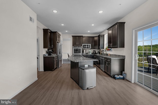 kitchen featuring stainless steel appliances, baseboards, and light wood-style floors