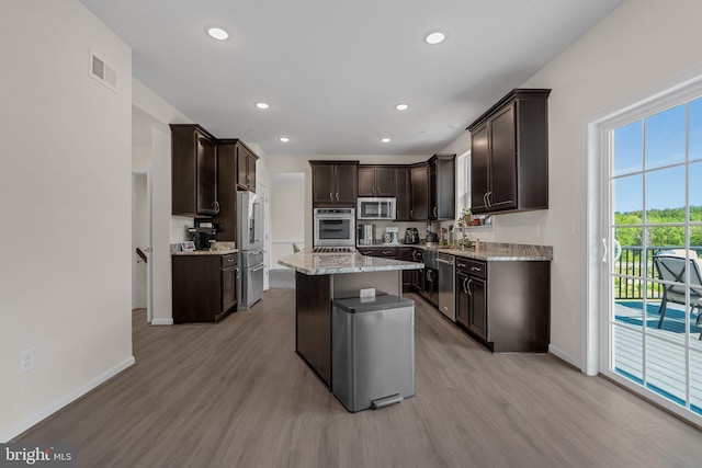 kitchen with stainless steel appliances, light wood-style flooring, visible vents, and dark brown cabinetry