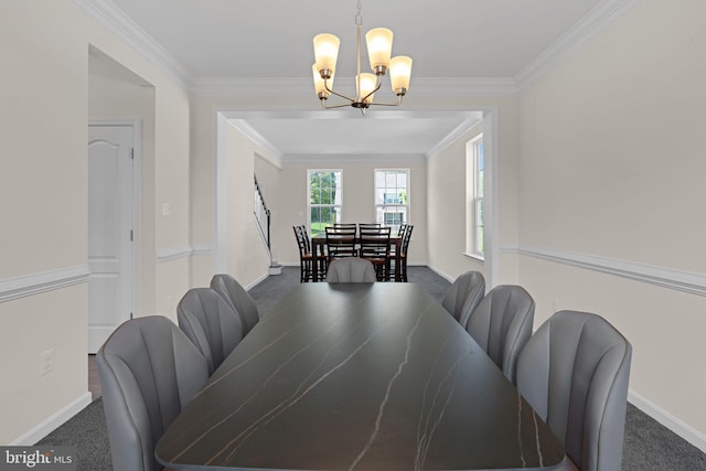 dining room featuring baseboards, a chandelier, crown molding, and carpet