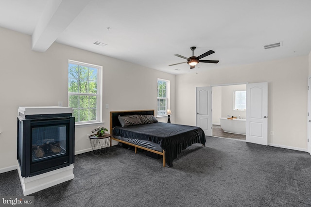 carpeted bedroom featuring multiple windows, visible vents, baseboards, and a glass covered fireplace