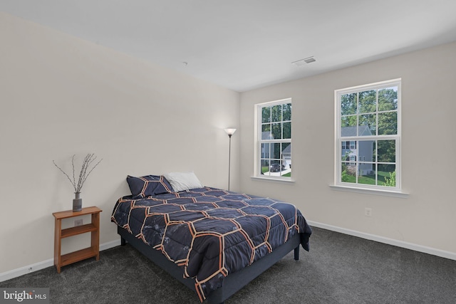 carpeted bedroom featuring baseboards and visible vents