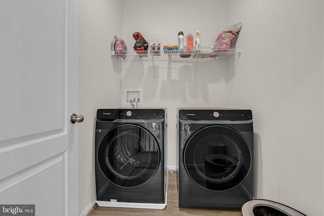 washroom with washing machine and dryer, laundry area, baseboards, and wood finished floors