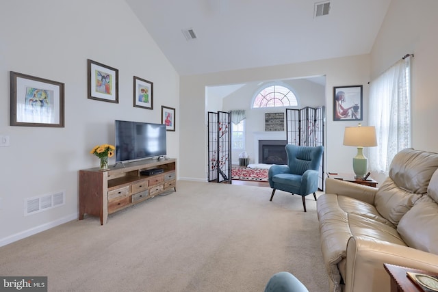 carpeted living room with visible vents, high vaulted ceiling, and baseboards
