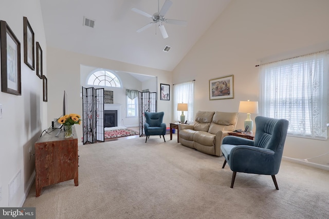 living area featuring visible vents, high vaulted ceiling, and light carpet