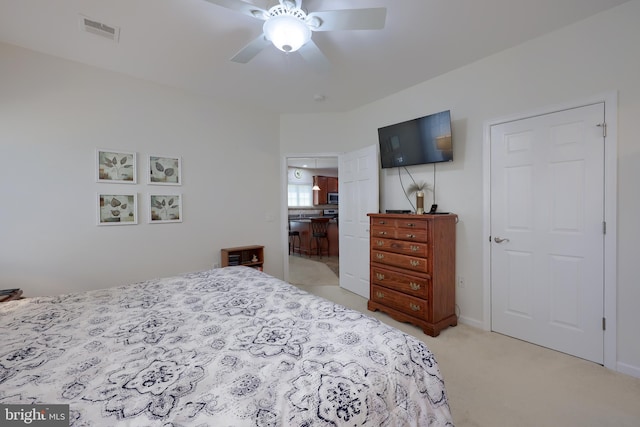 bedroom featuring visible vents, light carpet, ensuite bath, and ceiling fan