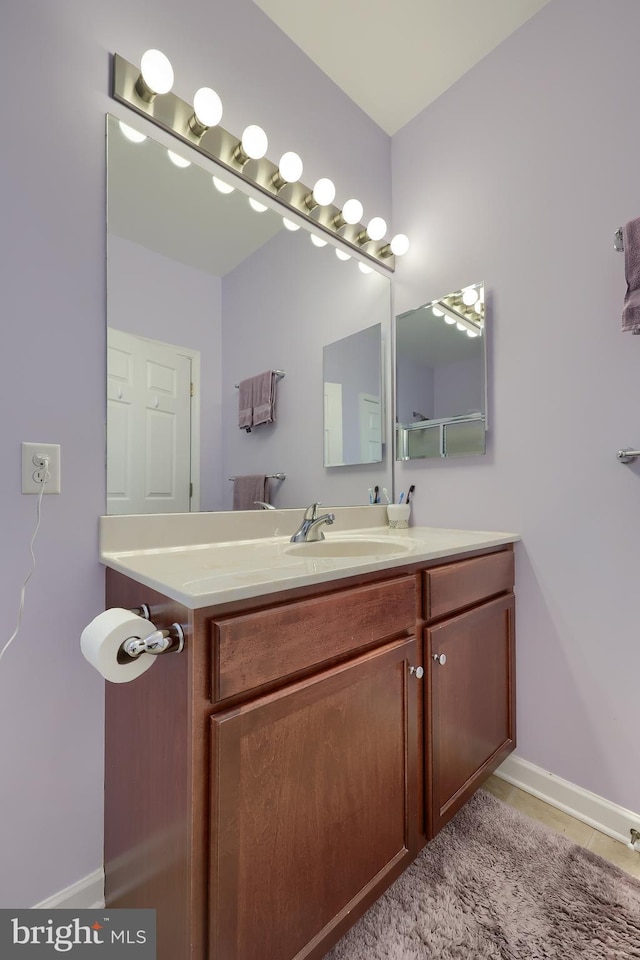 bathroom featuring baseboards, tile patterned flooring, and vanity