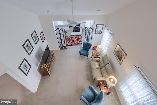 living room with baseboards, visible vents, a ceiling fan, and carpet floors