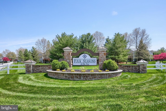 community sign featuring a yard and fence