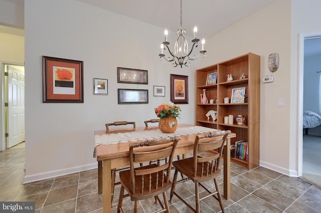 dining space featuring baseboards and a notable chandelier
