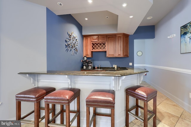 bar with recessed lighting, indoor wet bar, and baseboards