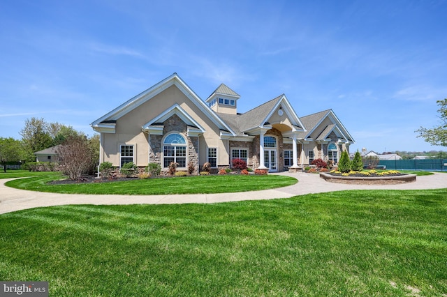 craftsman inspired home with fence, a front yard, stucco siding, and stone siding