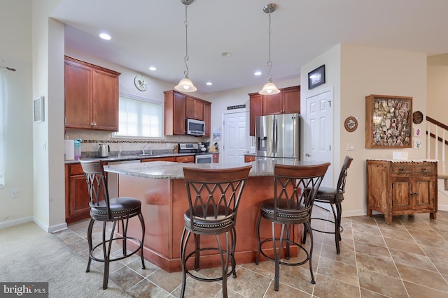 kitchen with a breakfast bar area, a center island, stainless steel appliances, and decorative backsplash
