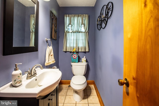 half bath featuring toilet, baseboards, tile patterned flooring, and vanity