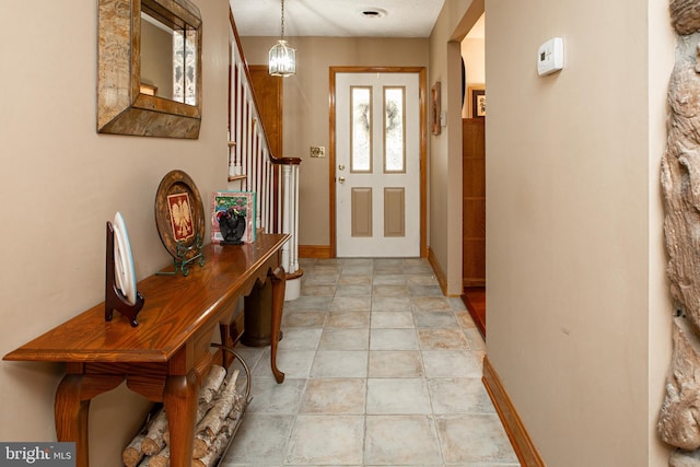 doorway featuring baseboards and stairs