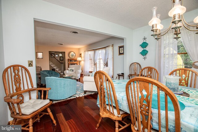 dining space with visible vents, a textured ceiling, stairs, and dark wood-style floors