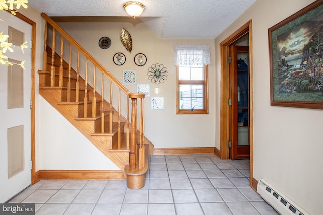 entrance foyer with a baseboard radiator, a textured ceiling, stairs, and light tile patterned flooring