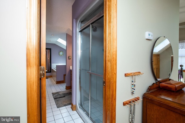 full bath with vaulted ceiling, vanity, tile patterned flooring, and a shower stall
