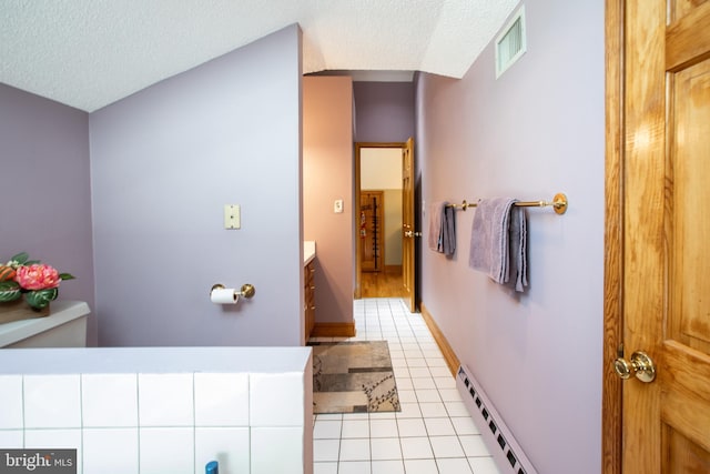 bathroom featuring a baseboard heating unit, a textured ceiling, visible vents, and tile patterned floors