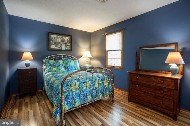 bedroom featuring baseboards and wood finished floors