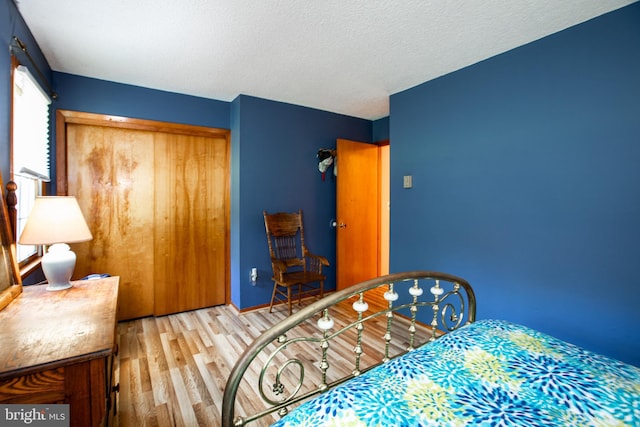 bedroom with a closet, a textured ceiling, and wood finished floors