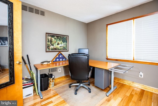 home office featuring visible vents and wood finished floors