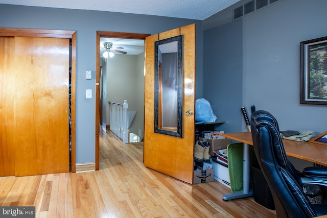 home office with ceiling fan, visible vents, and wood finished floors