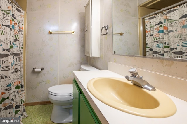 full bath featuring curtained shower, vanity, baseboards, toilet, and wallpapered walls