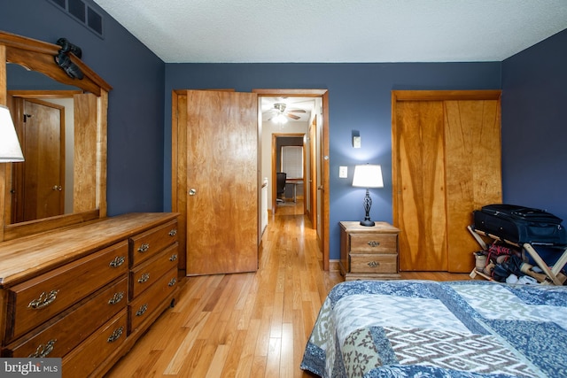 bedroom featuring a closet, light wood-style flooring, and visible vents