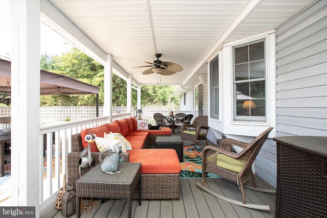 deck with outdoor dining area, an outdoor living space, and a ceiling fan