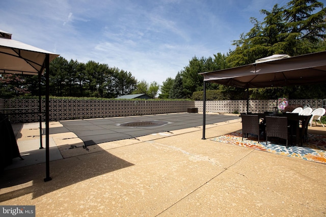 view of patio / terrace featuring a gazebo, fence, and outdoor dining area