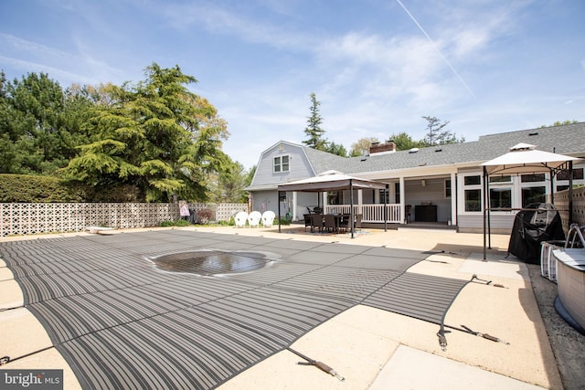 view of pool with fence, outdoor dining area, a gazebo, and a patio area