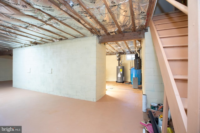 unfinished basement with stairs and water heater