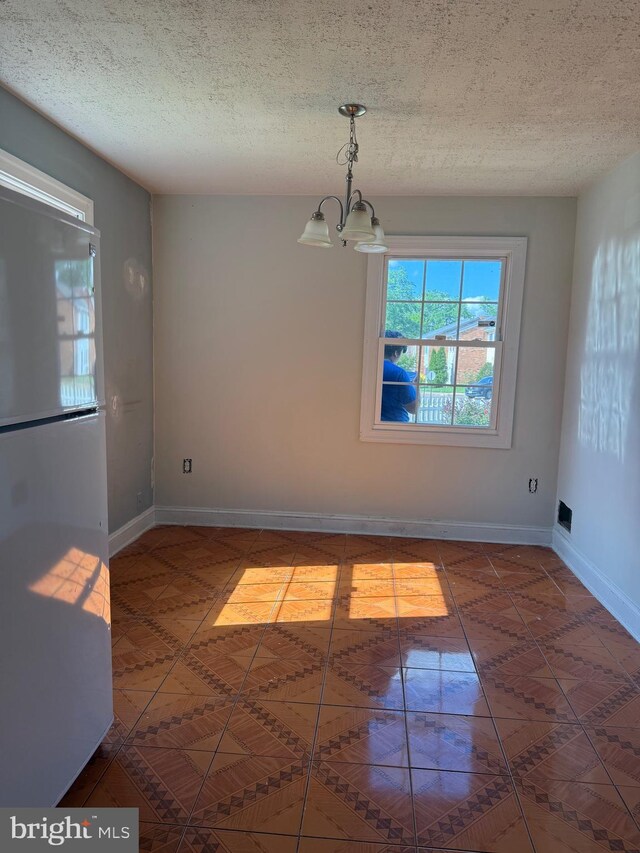7601 Somerset Ln, Manassas, VA 20111 - unfurnished dining area with a chandelier, tile patterned flooring, baseboards, and a textured ceiling