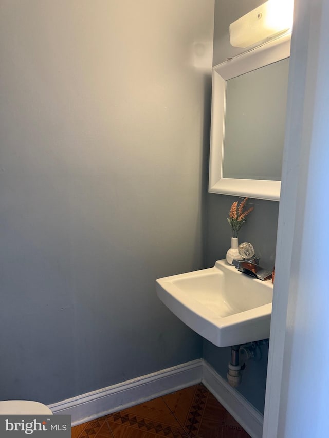 7601 Somerset Ln, Manassas, VA 20111 - bathroom featuring baseboards, toilet, and a sink