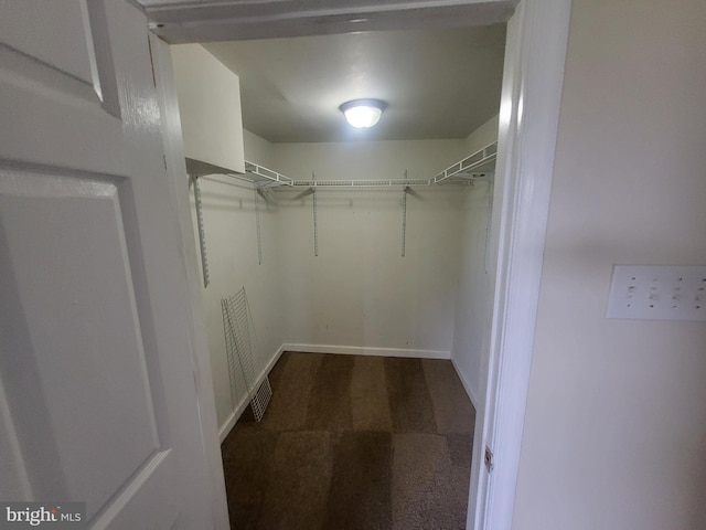 walk in closet featuring dark carpet and visible vents