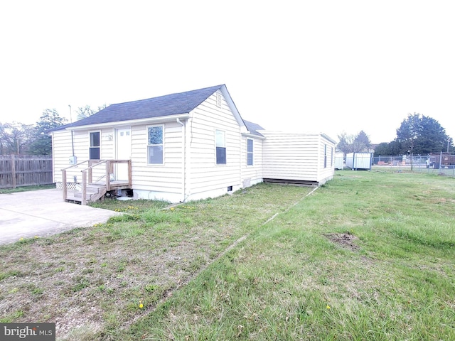view of side of property with a patio area, a lawn, and fence