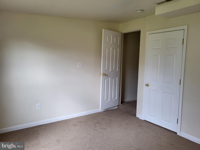 unfurnished bedroom featuring carpet floors and baseboards