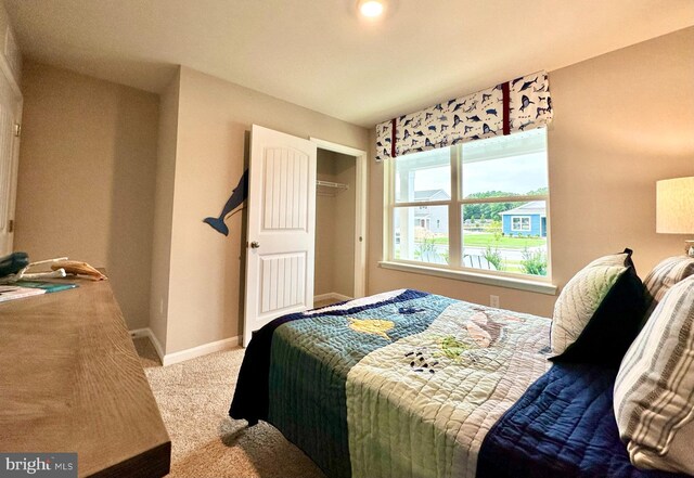 carpeted bedroom featuring a closet and baseboards