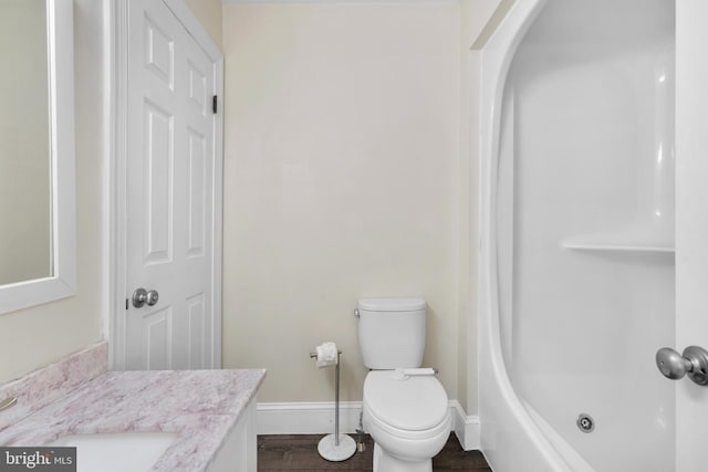 full bathroom with tub / shower combination, baseboards, toilet, wood finished floors, and vanity