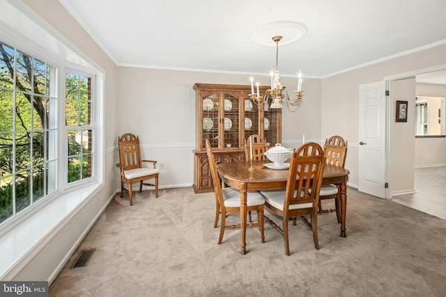 dining room with crown molding, visible vents, light carpet, and a chandelier